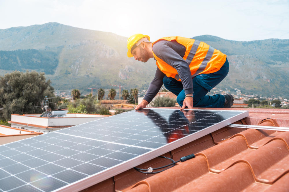 Arbeiter montiert Energiesystem mit Solarpanel auf Dach